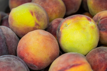 A group of ripe peaches in a bowl
