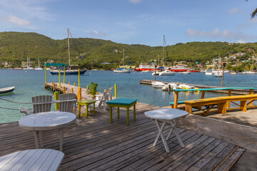 Fototapeta na wymiar Saint Vincent and the Grenadines,jetty and tables in Admiralty Bay, Bequia