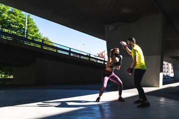 Fototapeta premium Spanish Woman Training Boxing with Coach Outdoors. Boxing Concept.