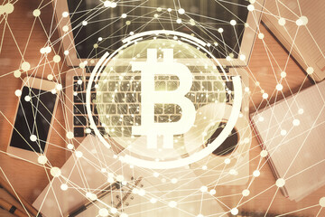 Blockchain theme hologram drawings over computer on the desktop background. Top view. Double...