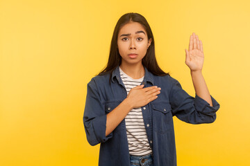 I swear! Portrait of honest girl in denim shirt taking sacred oath, making solemn vow in ceremonial...