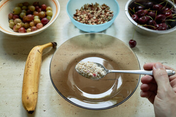 cooking healthy breakfast. oatmeal with banana, gooseberyy,cherry and nuts. healthy lifestyle concept. keto diet.