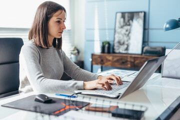 Woman using laptop while sitting at her desk. Businesswoman in the office working on laptop