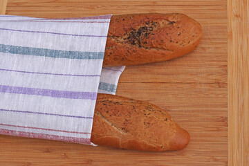 Baguettes on a towel on a wooden background. top view. Space for design