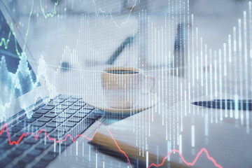 Double exposure of financial chart drawing and desktop with coffee and items on table background. Concept of forex market trading