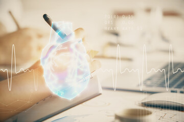 Double exposure of heart drawing over people taking notes background. Concept of medical education