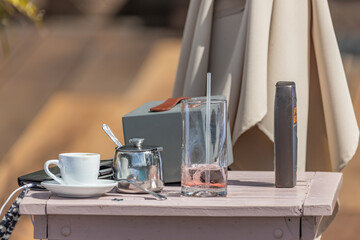 Table with empty glass, coffee cup, sunscreen and phone, Saint Vincent, Saint Vincent and the Grenadines