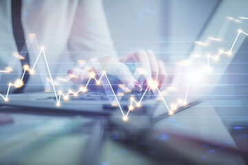 Double exposure of businesswoman hands typing on computer and financial graph hologram drawing. Stock market analysis concept.