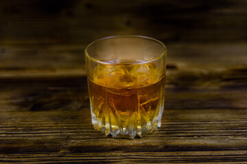 Glass of whiskey on the dark wooden background