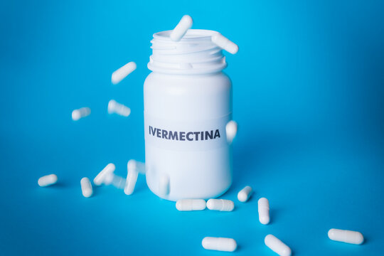 Chuva de comprimidos de Ivermectina sobre a embalagem de Ivermectina ao fundo azul claro