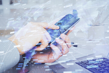 Double exposure of man's hand holding and using a digital device and data theme hologram drawing. Technology concept.