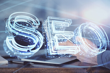 Multi exposure of man's hands holding and using a digital device and seo drawing. search...