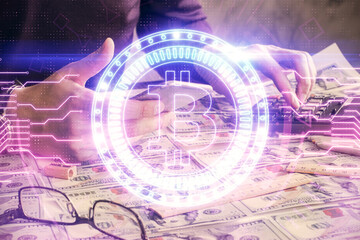 Double exposure of man's hands holding and using a phone and crypto currency blockchain theme...