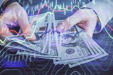 Multi exposure of financial graph drawing hologram and USA dollars bills and man hands. Analysis concept.