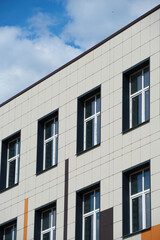 facade of a modern building on a bright Sunny day, siding and Windows, beautiful exterior of the new building