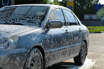 Fototapeta na wymiar Washing car at self service station with foam. Selective focus. 