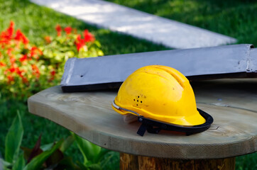 Dirty orange workman's safety helmet (hard hat) on wooden table