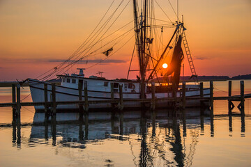 Fototapeta na wymiar Sunset on a shrimp boat moored at the Port Royal harbor, Georgia.
