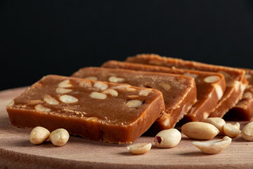 Peanut home toffee on a wooden board. Slices of eastern sweets with nuts.
