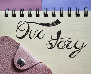 Our Stroy words lettering in copybook and wallet. Business story concept