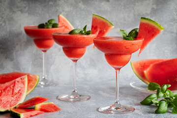 Frozen red drink margarita garnished with watermelon and basil.  Three red drinks in a row.