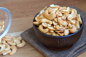 Cashew nuts peeled in a wooden bowl on table.