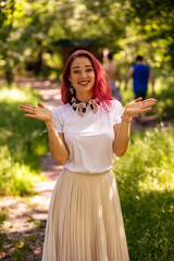 girl with colored hair in nature among the grass and trees in summer