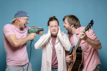 Unfortunate woman covered ears so as not to hear one neighbor playing the guitar, and the other...