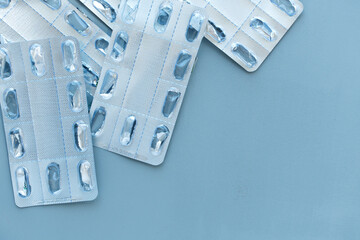 Empty blister packs of tablets on a blue background. Medical, environmental concept. Health therapy. Pandemic, epidemic, vaccination.