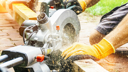 versatile craftsman working with wood to build a house on a summer day, DIY concept