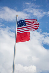 American Flag and Red Flag Flying at the Beach - High Hazard