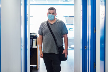 Chubby patient wearing face mask leaving a medical consultation