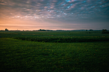 Beautiful green grass field with moody foggy cloudy morning sky in Gettysburg National Military Park, PA, America.