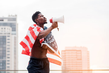 african american man with usa flag shouting into a megaphone in protest, black lives metter