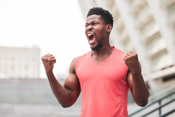 Naklejka premium african american guy screaming outdoors in summer city, annoyed man in stress