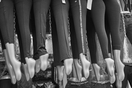 Collection of mannequin legs in tights hanging outside a shop