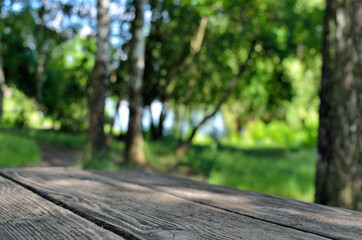 Wooden table on a background of green trees