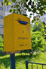 Yellow, old mailbox on a city street