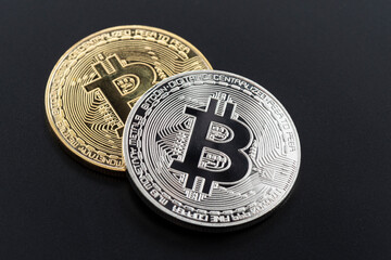 Golden and silver bitcoin isolated on the black background.