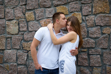 Obraz na płótnie Canvas young man tenderly kisses a girl on a temple on a date
