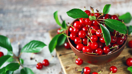 Selective focus. Red cherries with leaves in a bowl. Harvest cherries. Scarlet Cherries.