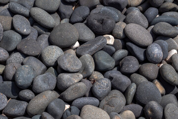 Close up macro photograph of blue river stone landscaping rocks on a sunny day casting harsh shadows making a great texture background image.