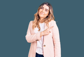 Young caucasian woman wearing business clothes pointing with hand finger to the side showing advertisement, serious and calm face