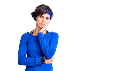 Beautiful young woman with short hair wearing training workout clothes thinking looking tired and bored with depression problems with crossed arms.