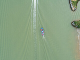 Aerial view of a boat sailing passed an island