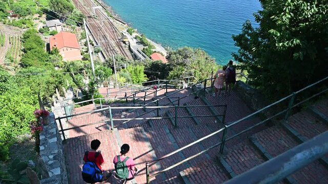 Corniglia, Liguria, Italy. June 2020. The staircase that leads from the station to the village, on top of the hill. Made of red brick, it has a zigzag path of 400 steps. People go through them.