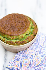Spinach souflé in ramekin with patterned napkin