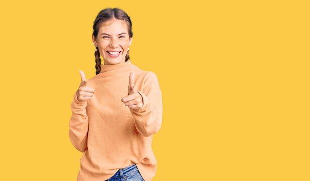 Beautiful caucasian woman with blonde hair wearing casual winter sweater pointing fingers to camera with happy and funny face. good energy and vibes.
