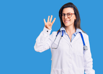 Young beautiful woman wearing doctor stethoscope and glasses showing and pointing up with fingers number four while smiling confident and happy.