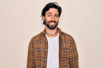 Fototapeta premium Young handsome hispanic bohemian man wearing hippie style standing over isolated background with a happy and cool smile on face. Lucky person.